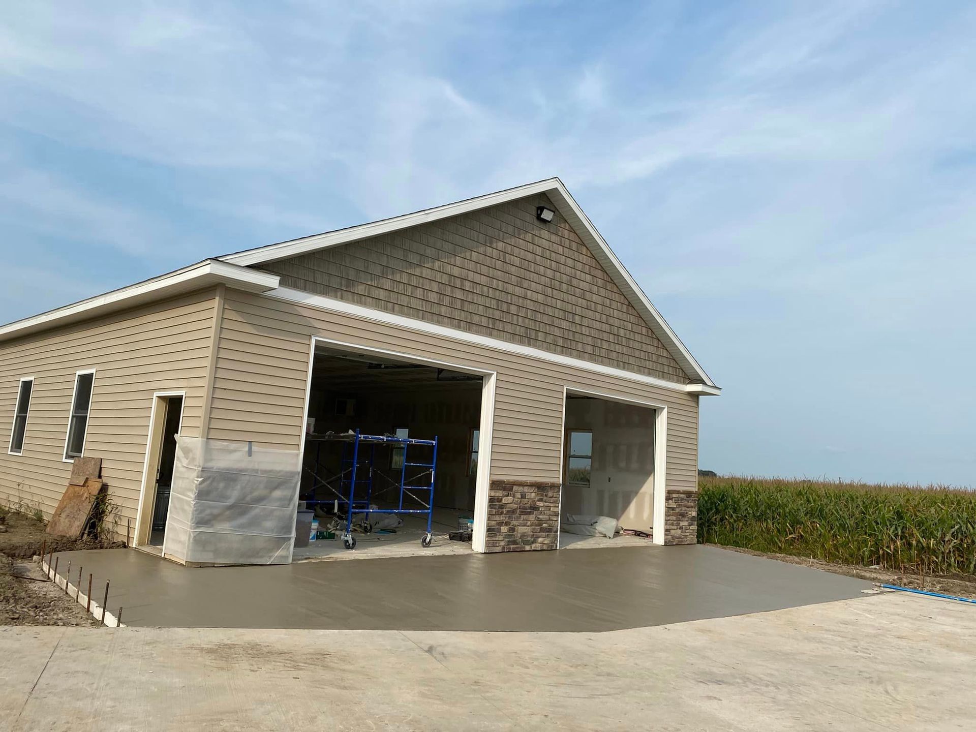 A large garage with a concrete driveway in front of it