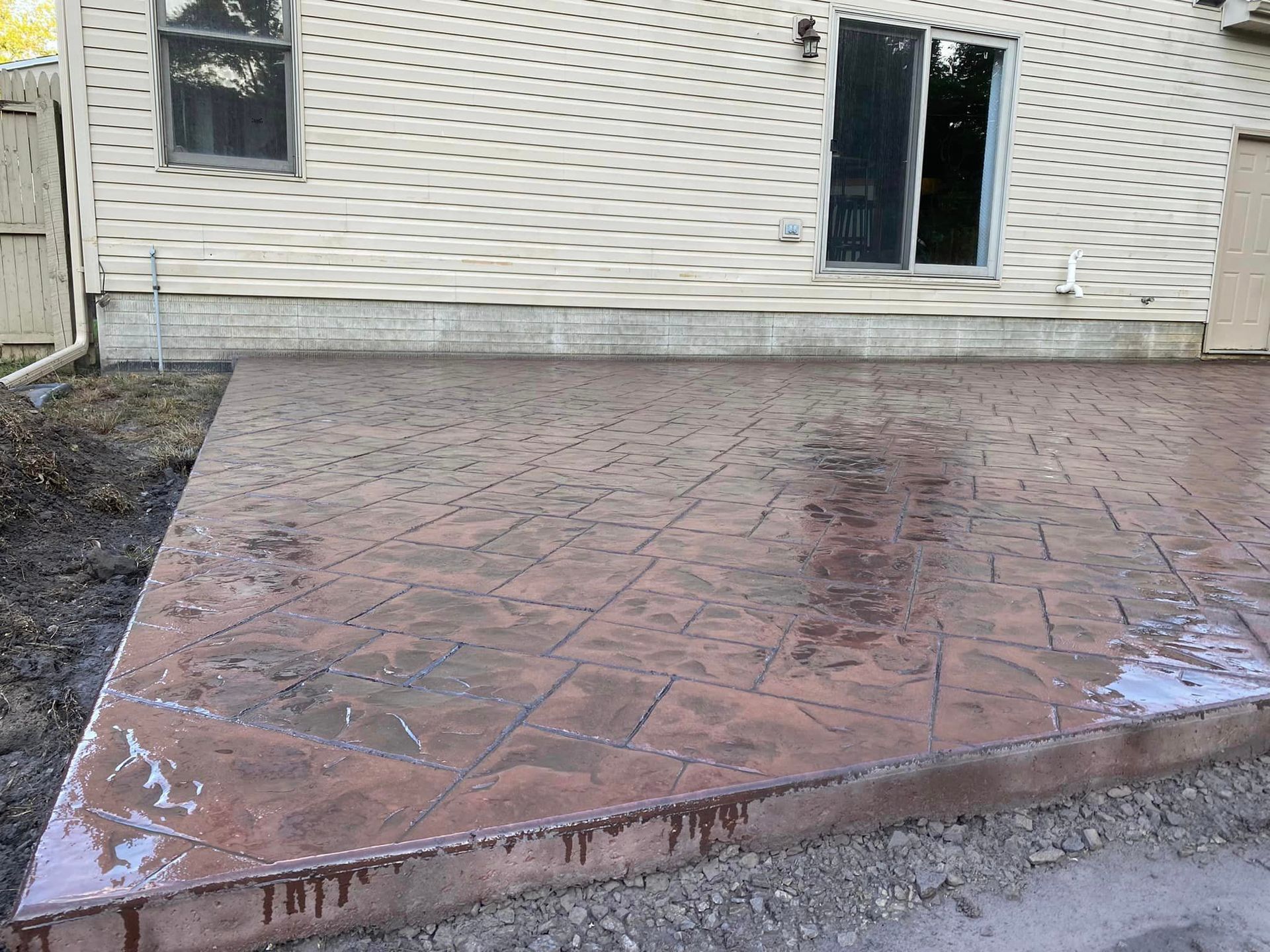 A concrete patio is being built in front of a house.