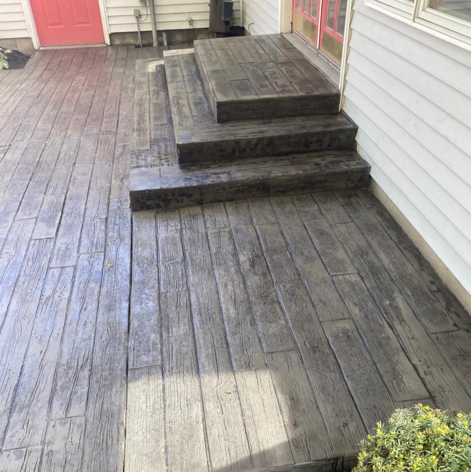 A concrete porch with stairs that look like wood