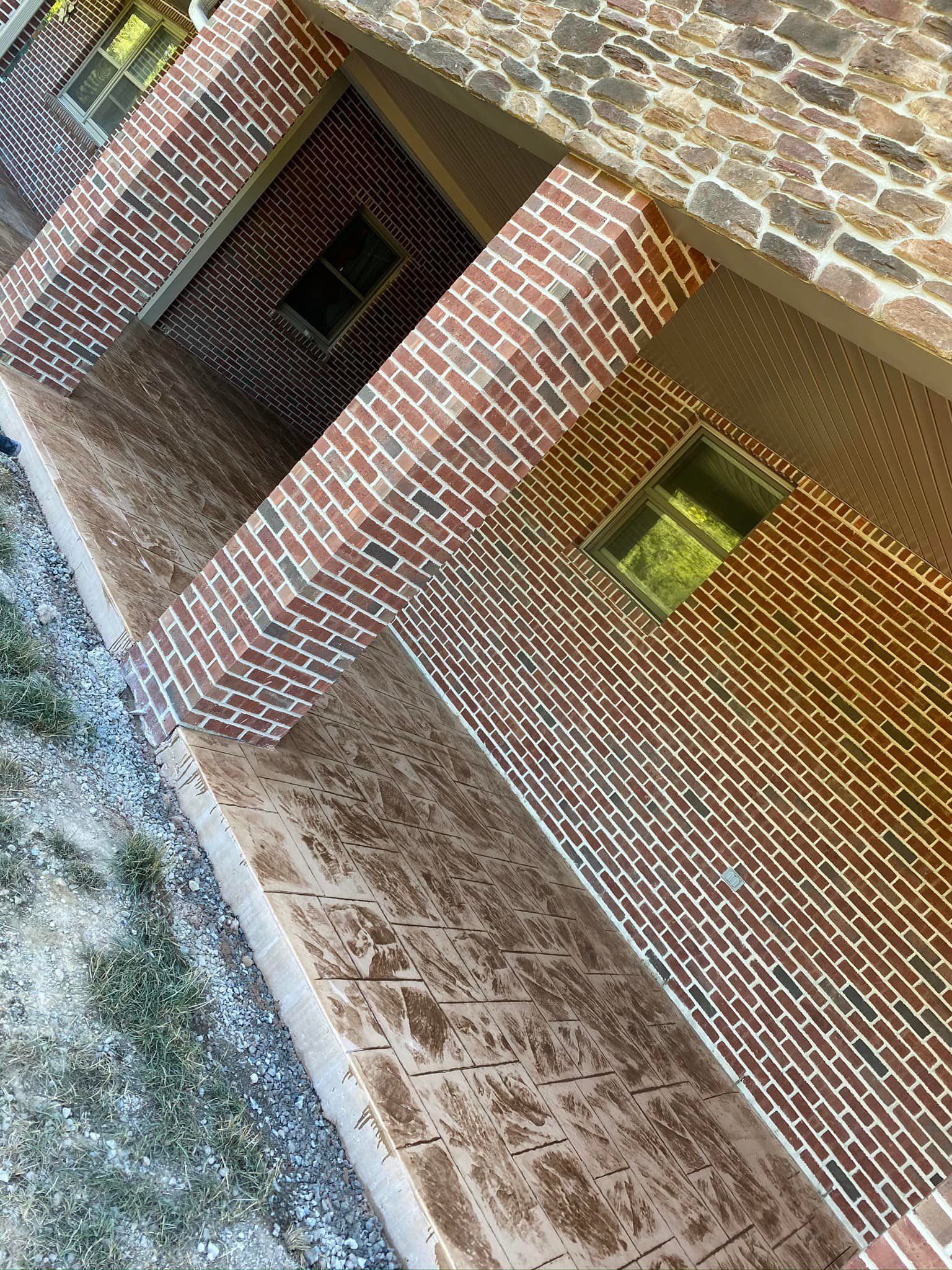 An aerial view of a brick building with a concrete walkway.
