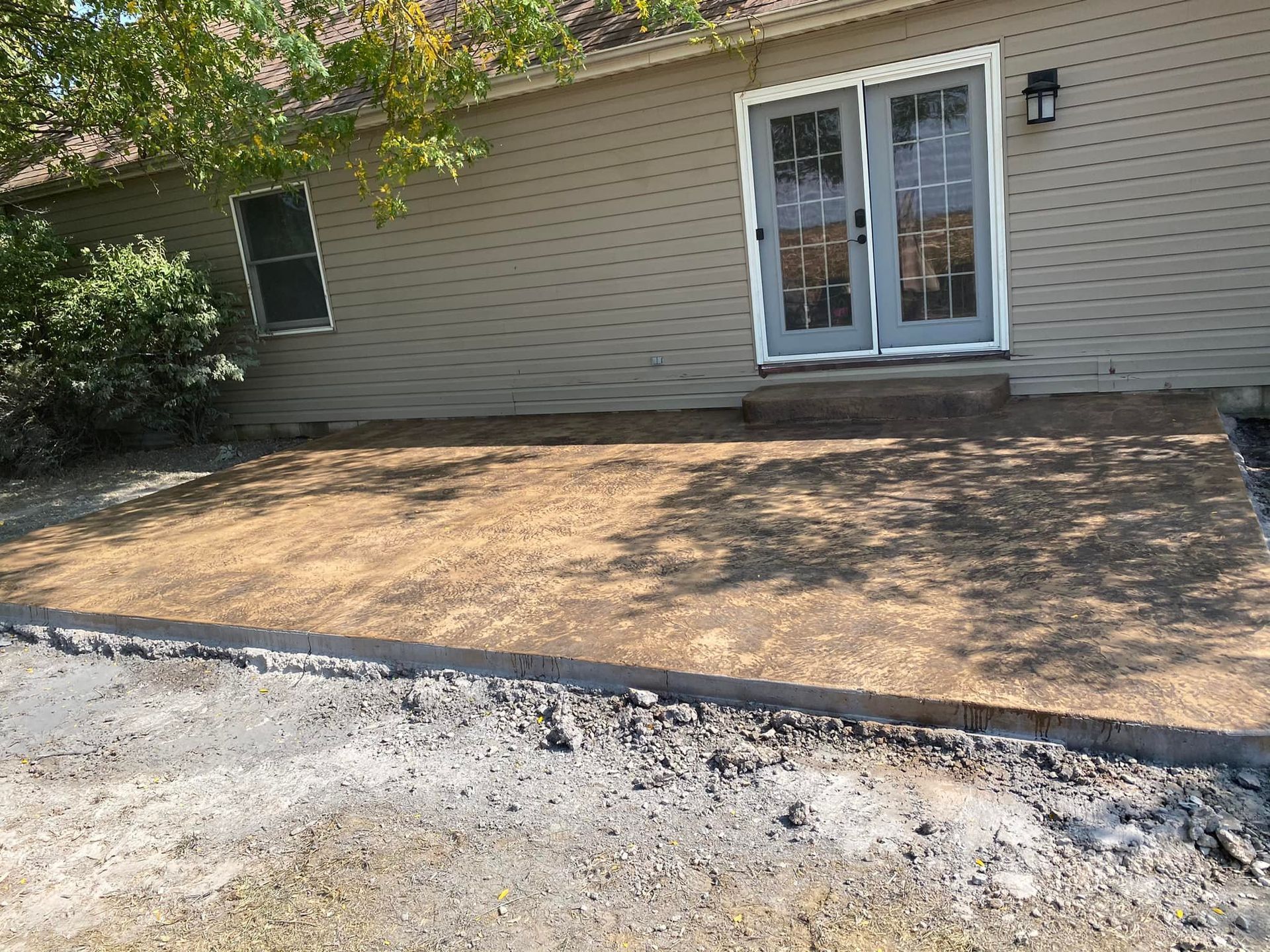 A house with a concrete patio in front of it.