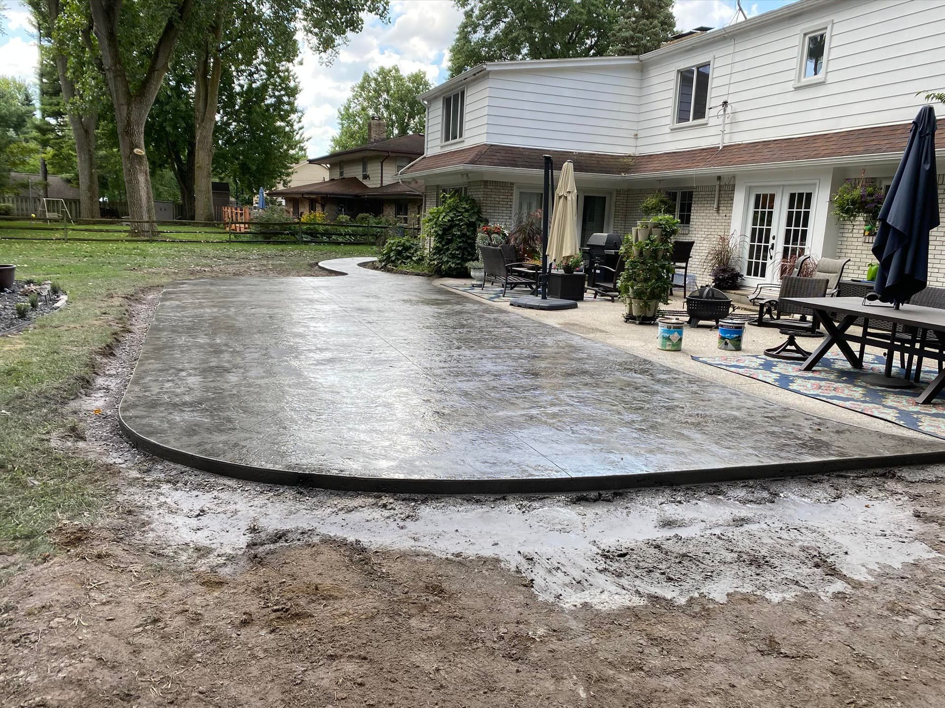 A large concrete patio is being built in front of a house.
