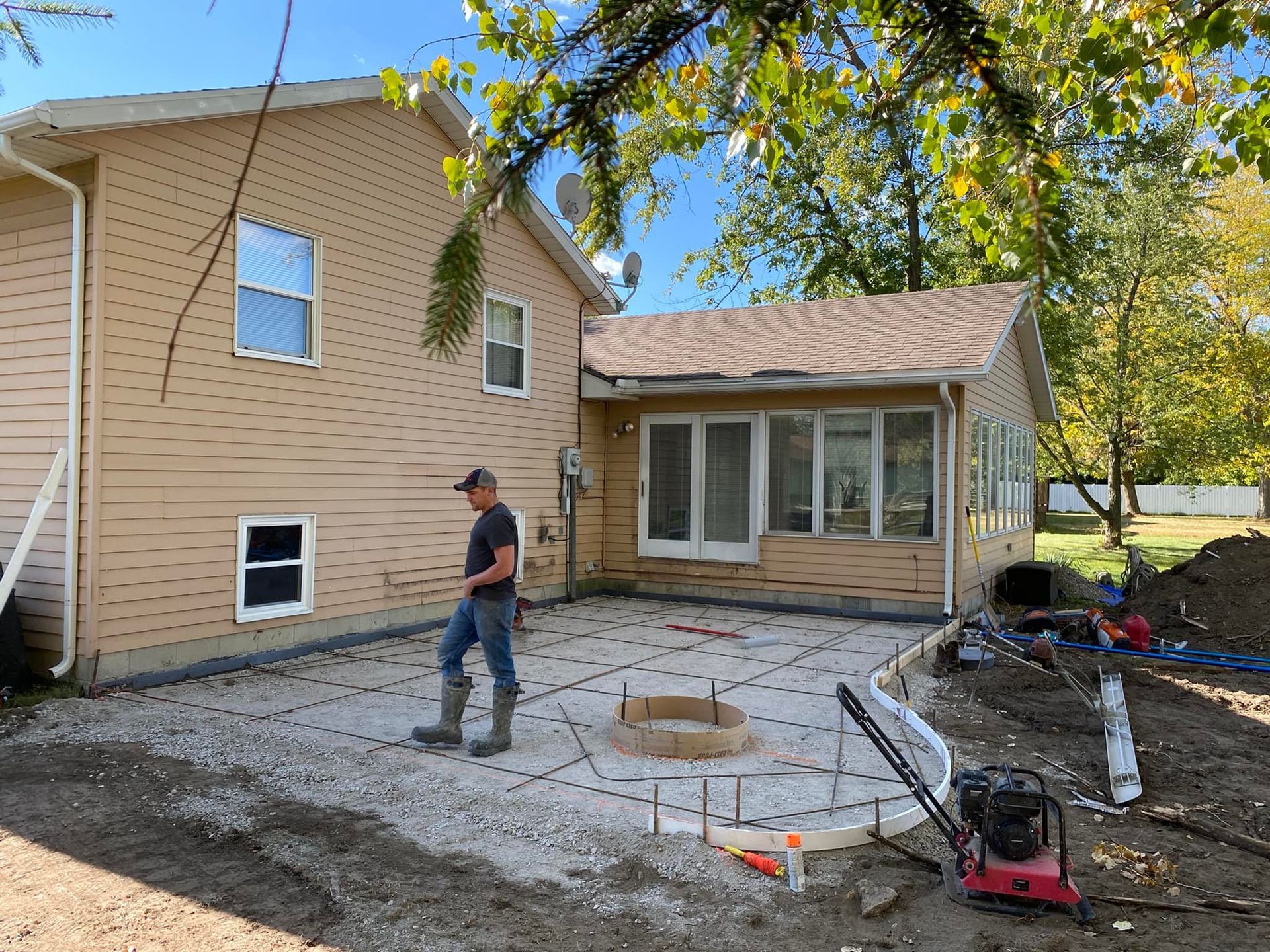 A man is standing on a concrete patio in front of a house.