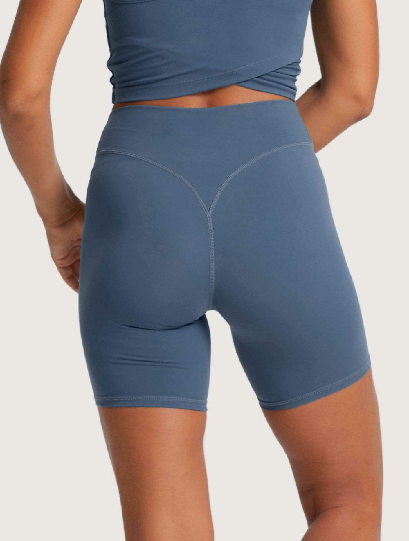 The back of a woman wearing blue shorts and a blue top