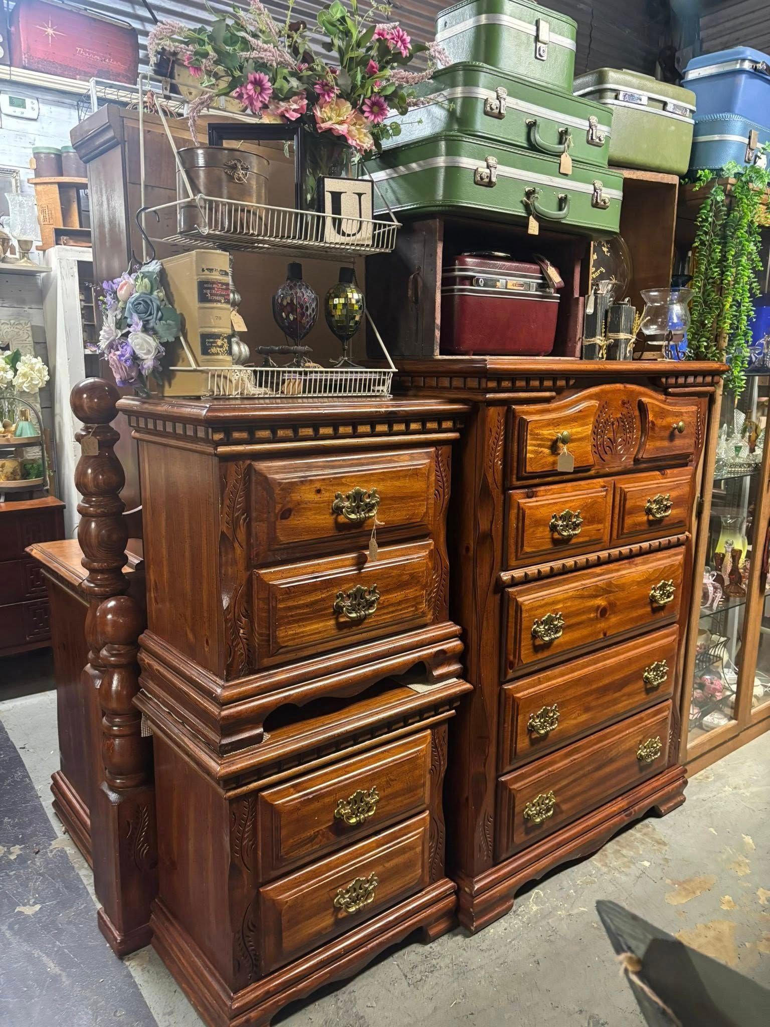 Wooden bedroom furniture set; nightstand and dresser. Stacked suitcases on top.