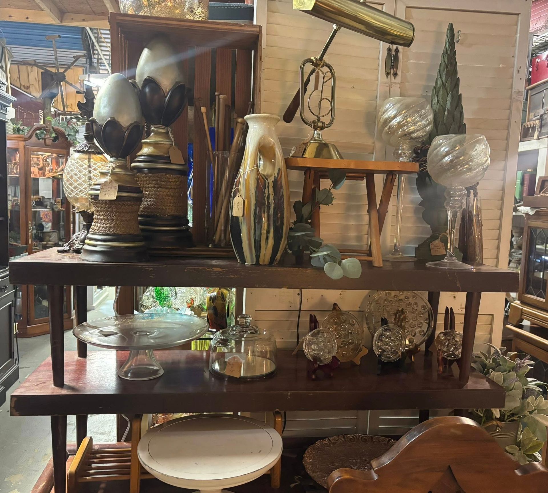 various items on display, lamps, vases, glass objects, and a small table.