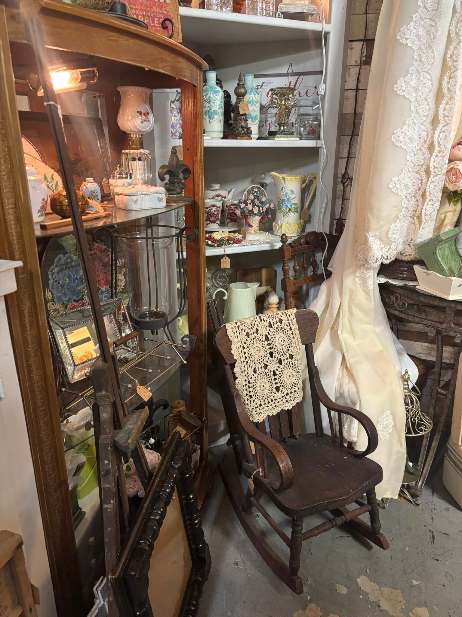 wooden rocking chair, shelves with various vintage items.