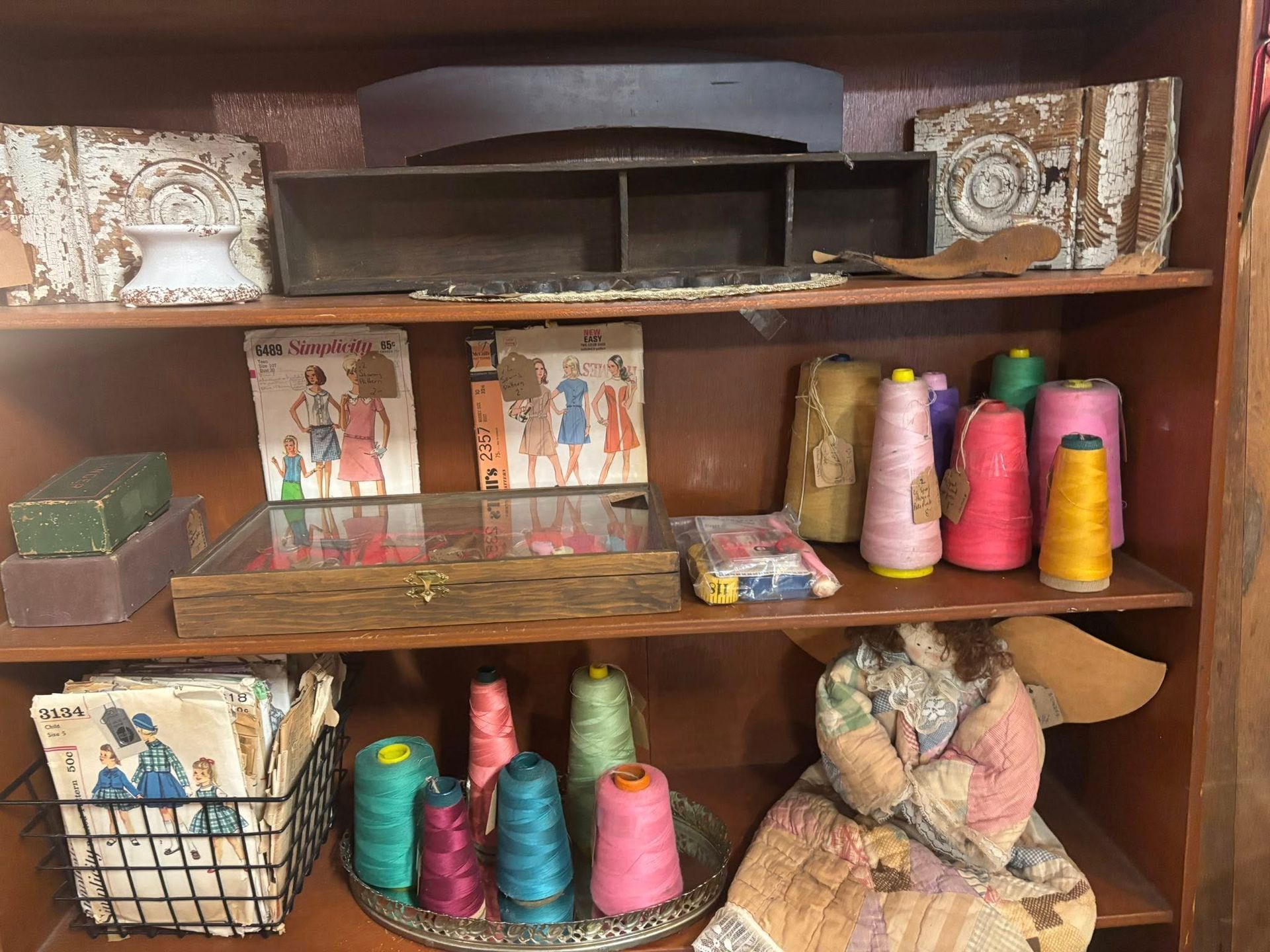  sewing supplies: spools of thread in various colors, vintage patterns, and decorative elements.