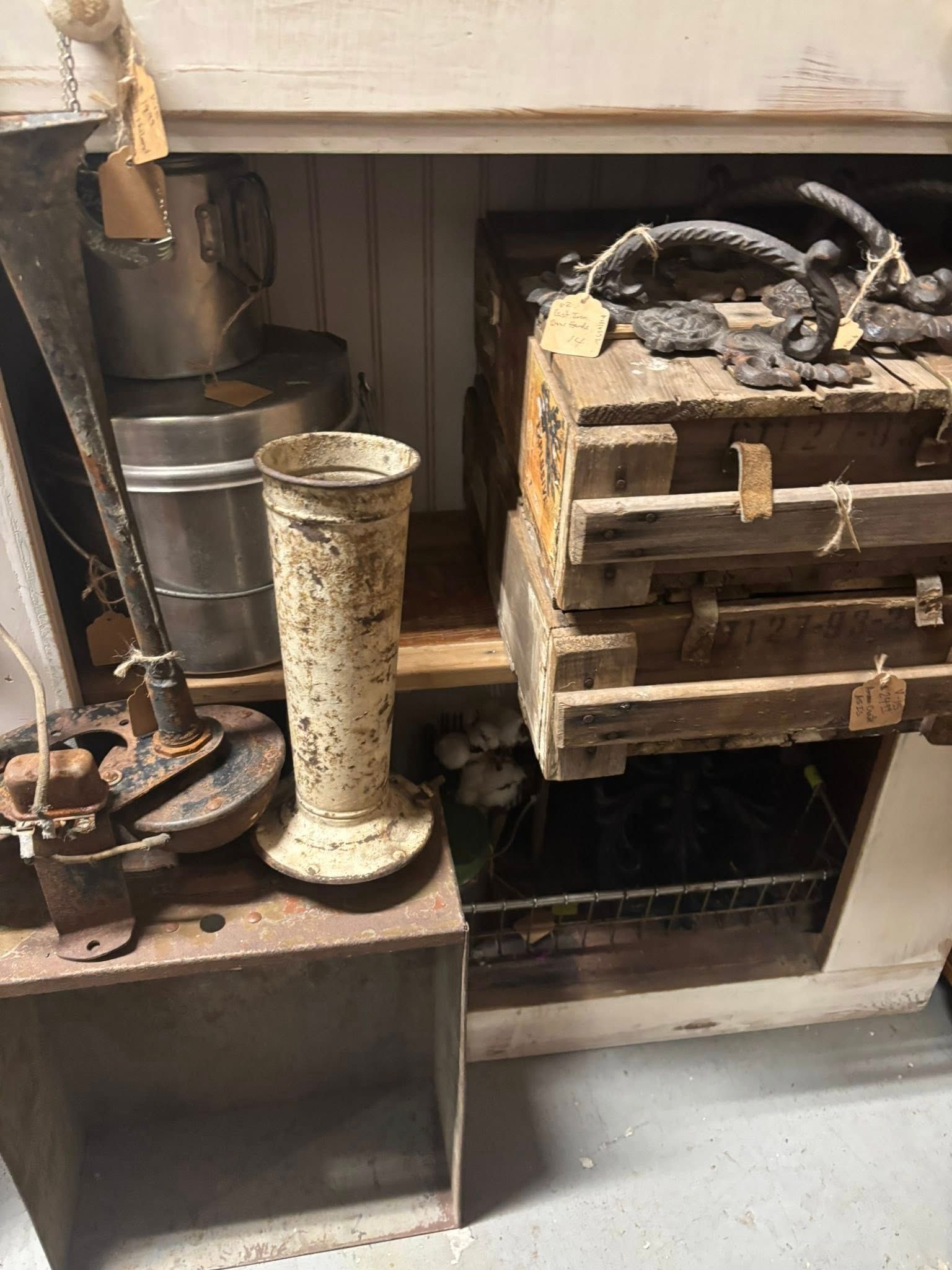 Metal decor various sixes and shapes White, tall vase in front of the crates.