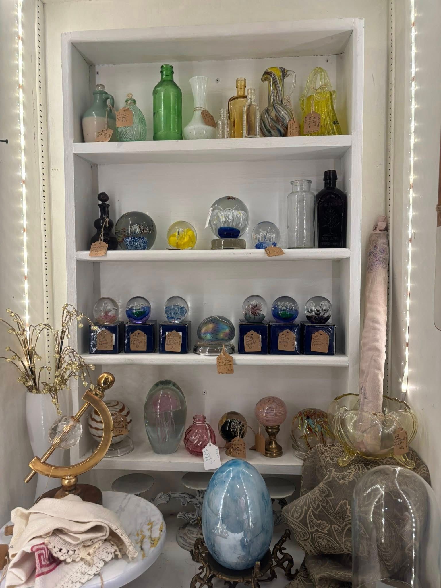 various glass bottles, globes, and decorative objects.