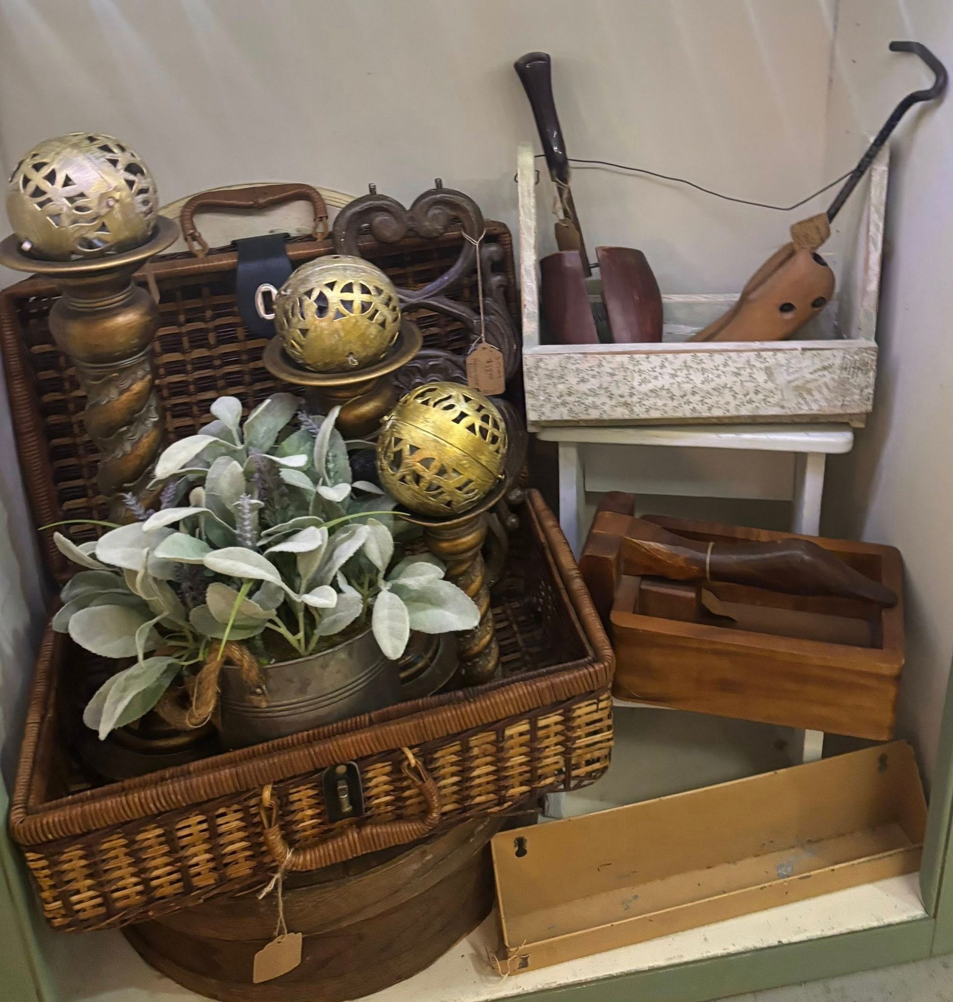  woven basket with plants, gold globes, shoe forms, and wooden accessories.