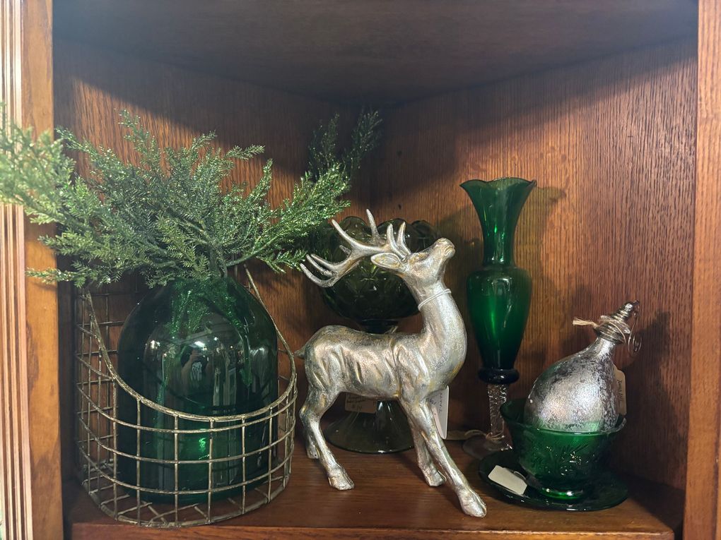 A cozy, antique room with a sofa, wooden furniture, a rug, and a chandelier.