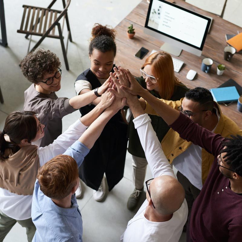 A group of people putting their hands together in a circle