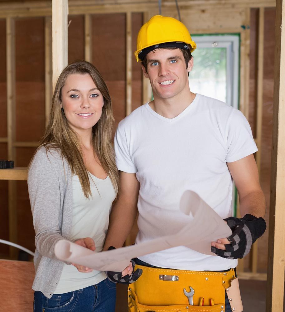 A man and a woman are standing next to each other in a building under construction.