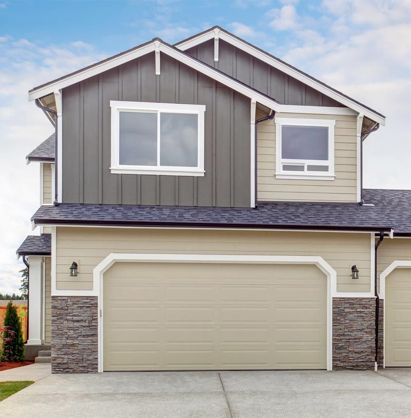 A house with two garage doors and a gray roof