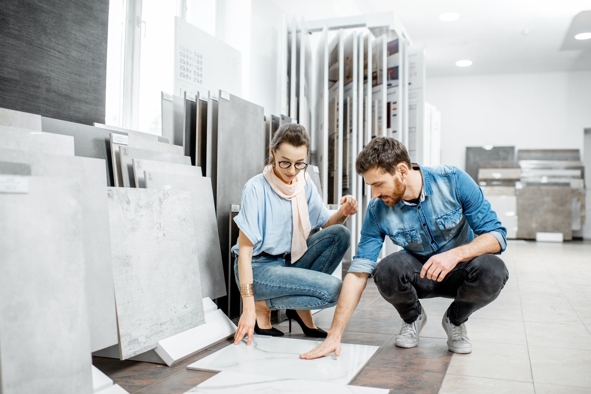 A couple is looking at some tiles in a store.