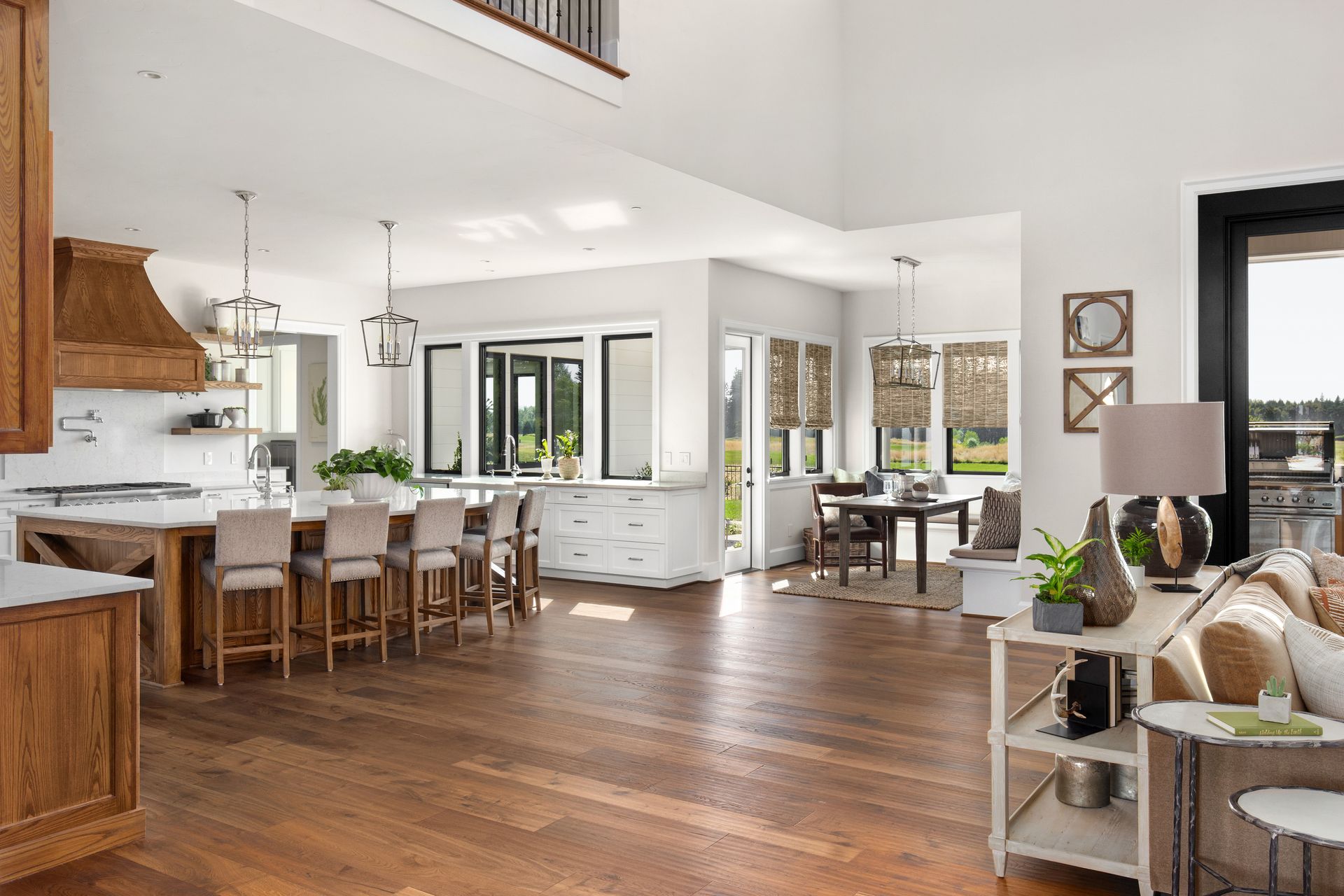 living space featuring a kitchen, dining area, and sitting area with hardwood floors and white walls