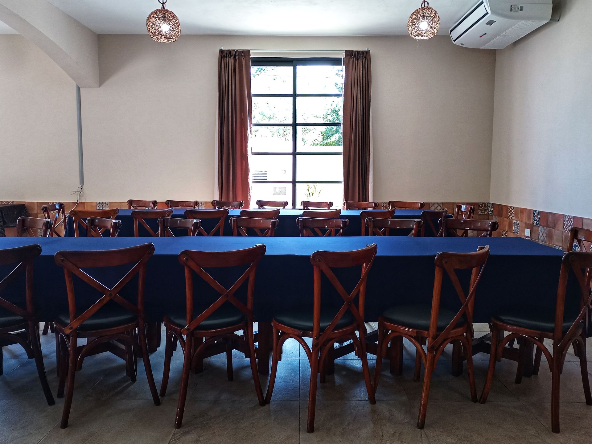 Una mesa larga y sillas en una habitación con ventana.