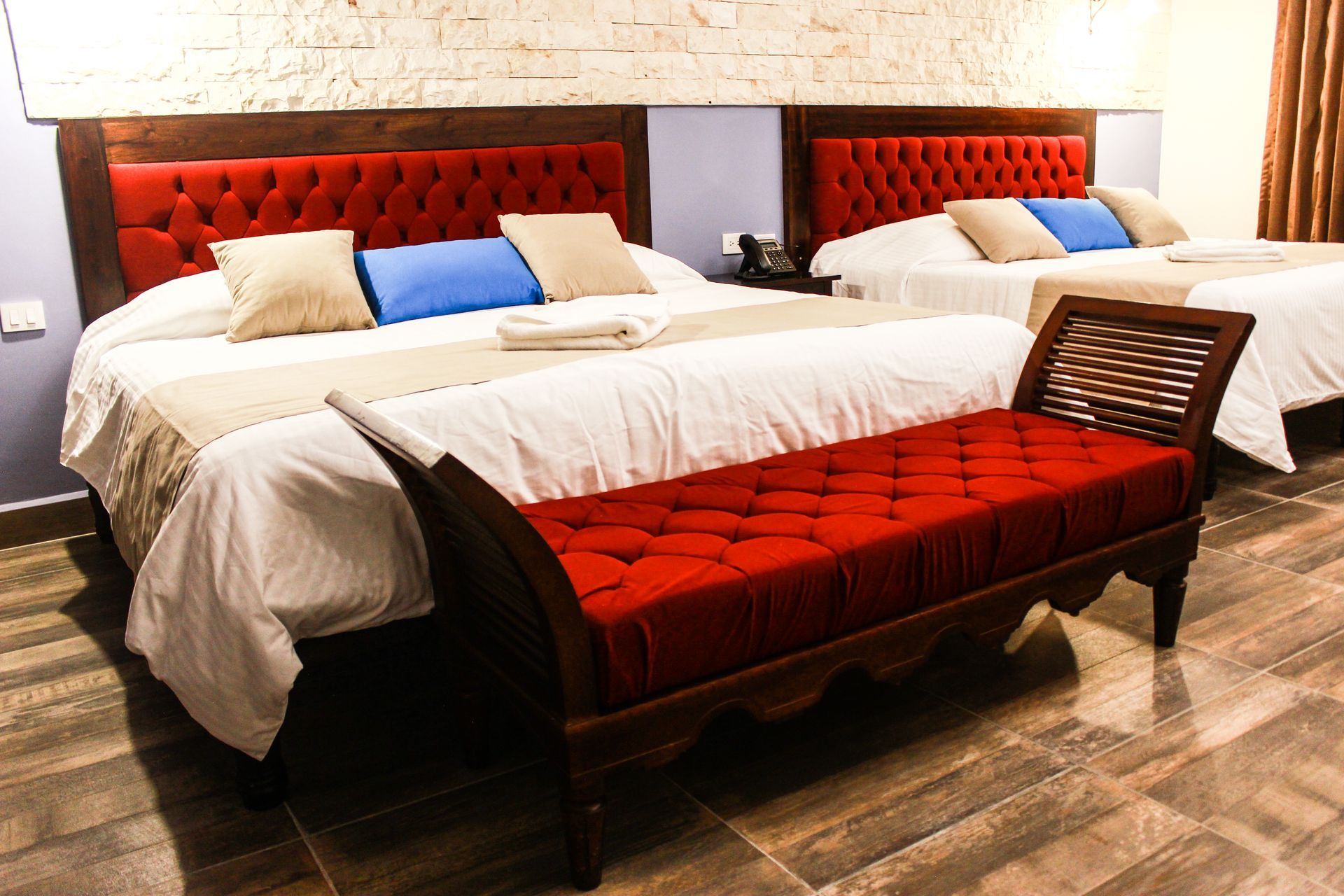 A hotel room with two beds and a bench