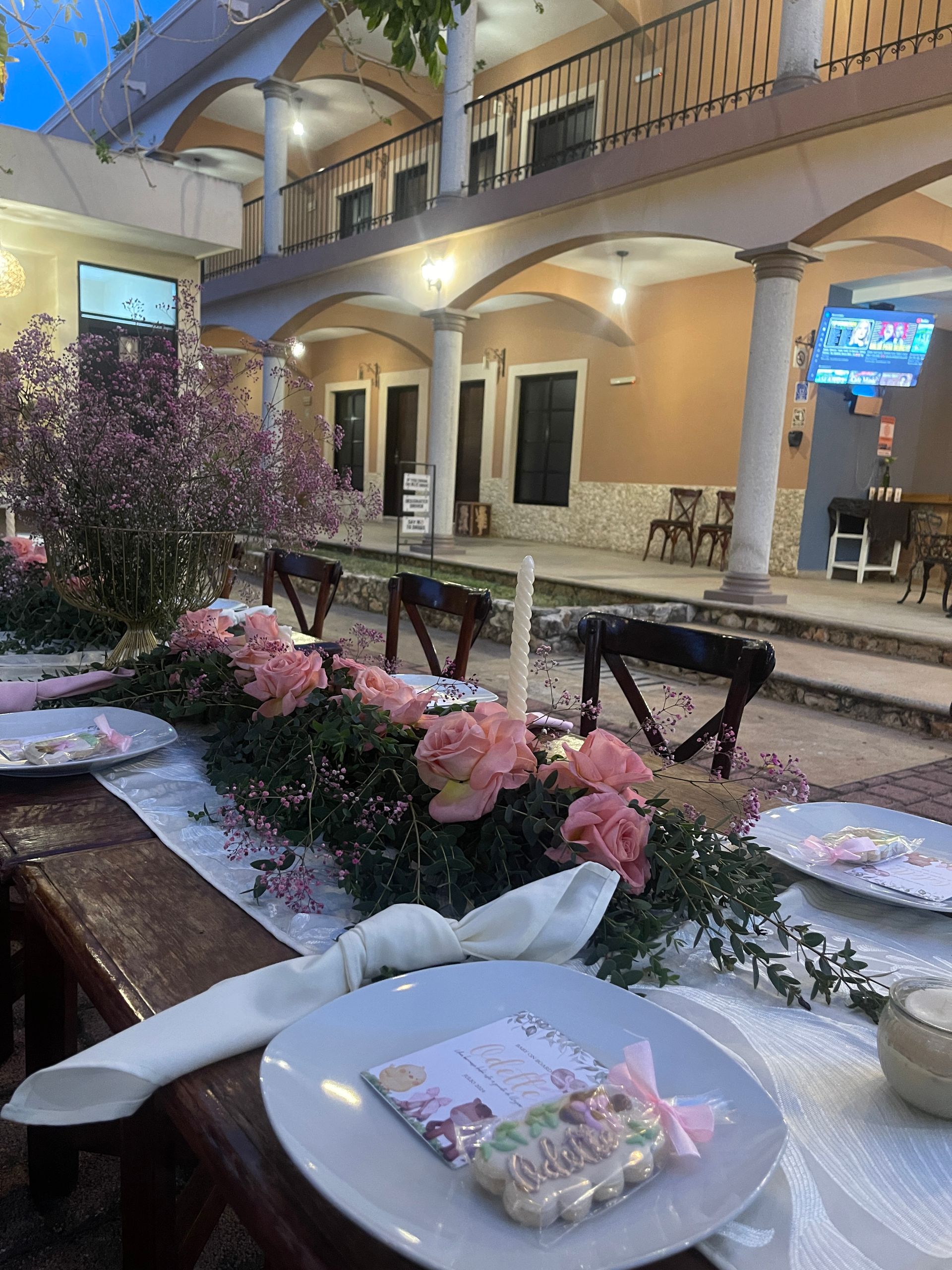 Una mesa con platos y flores delante de un edificio.