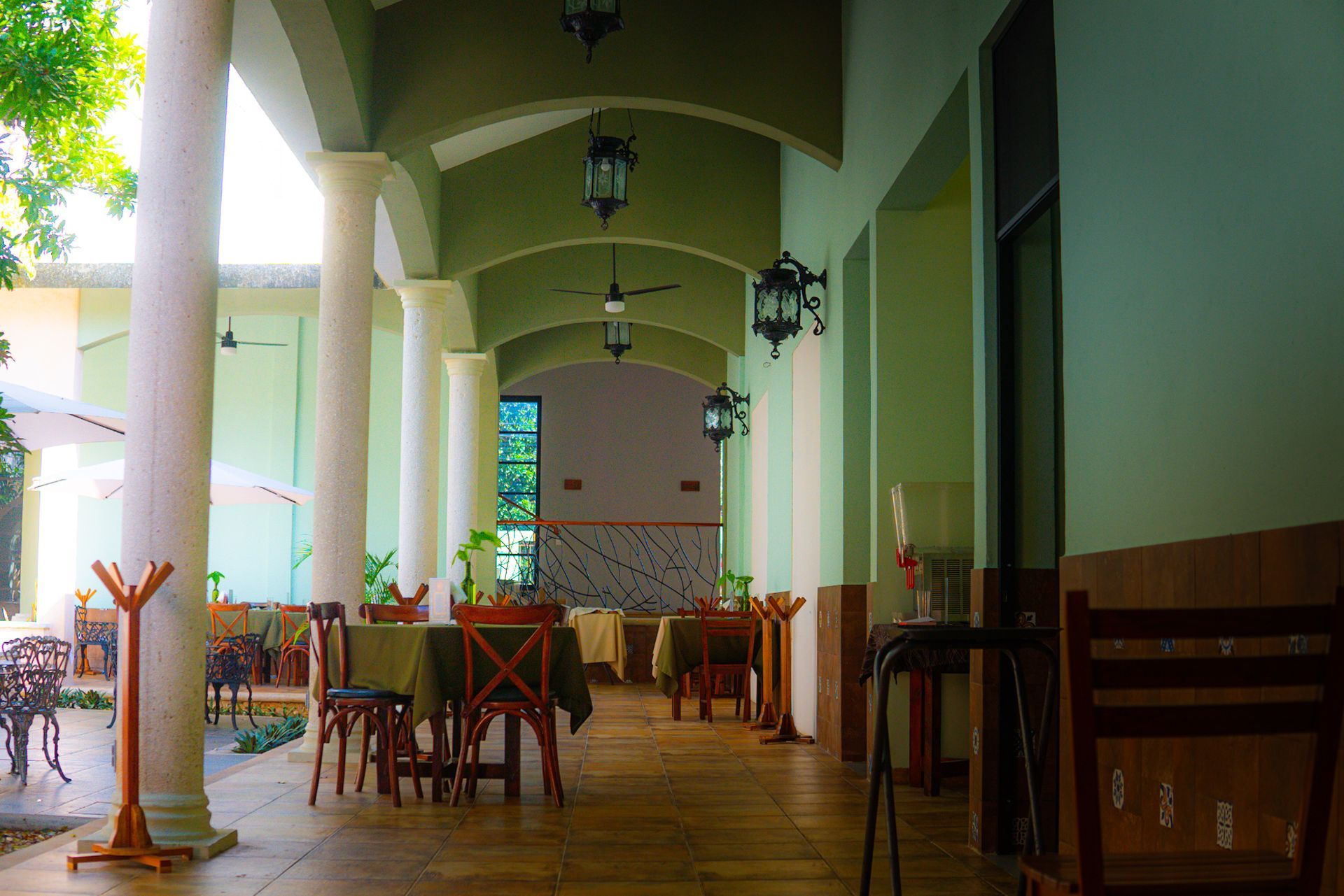 A long hallway with tables and chairs in a restaurant.
