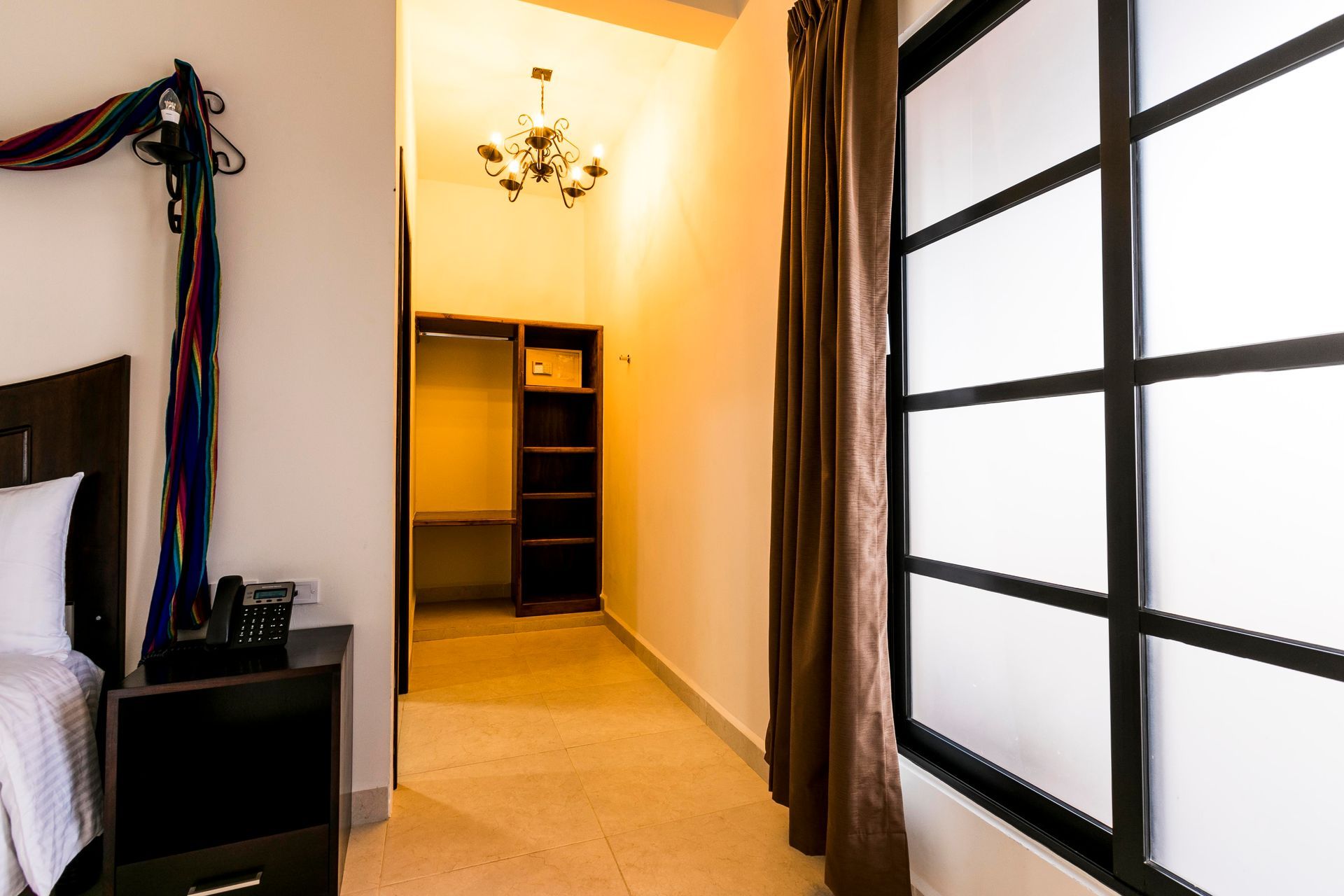 A bedroom with a bed , nightstand , window and closet.