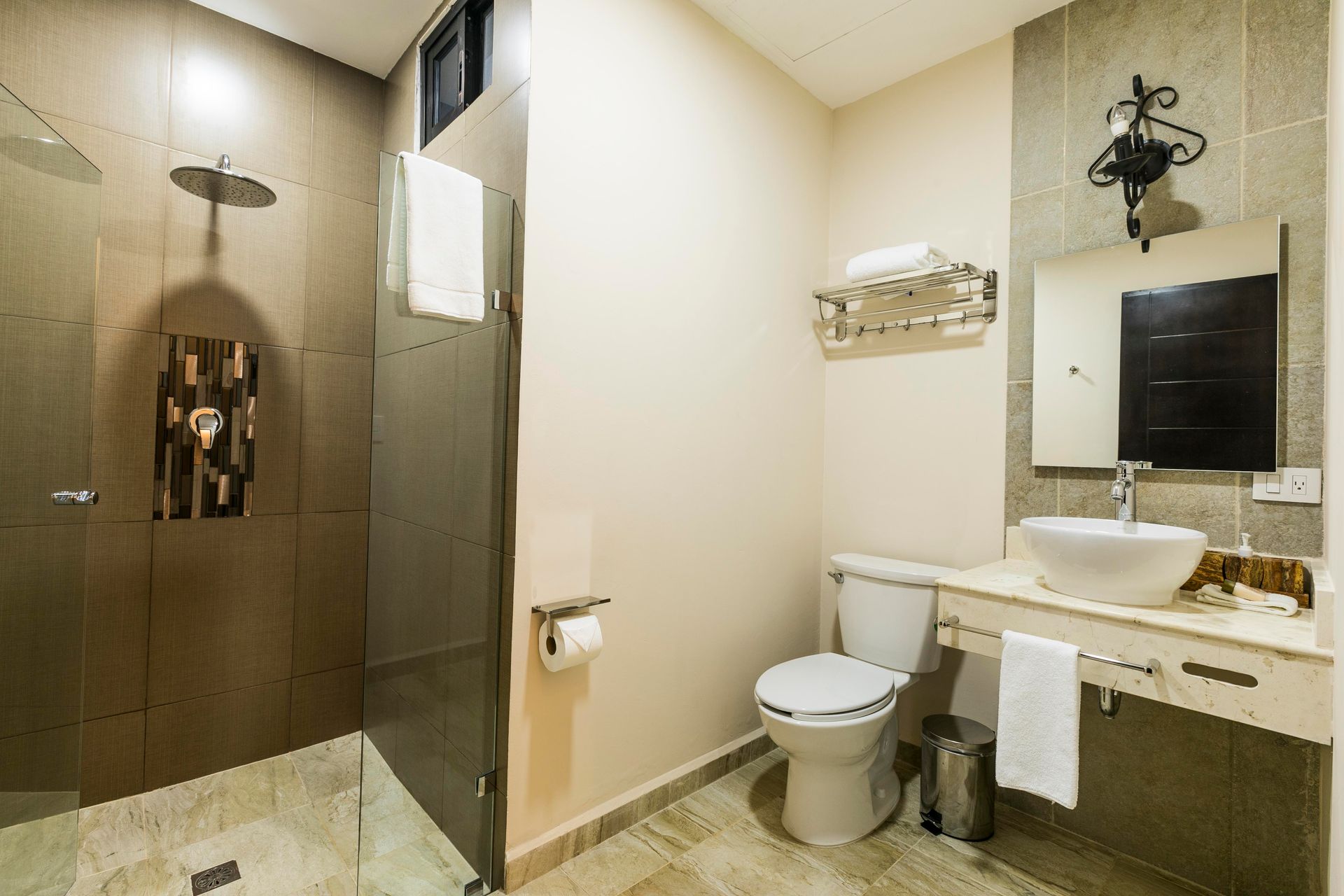 A bathroom with a toilet , sink and shower.