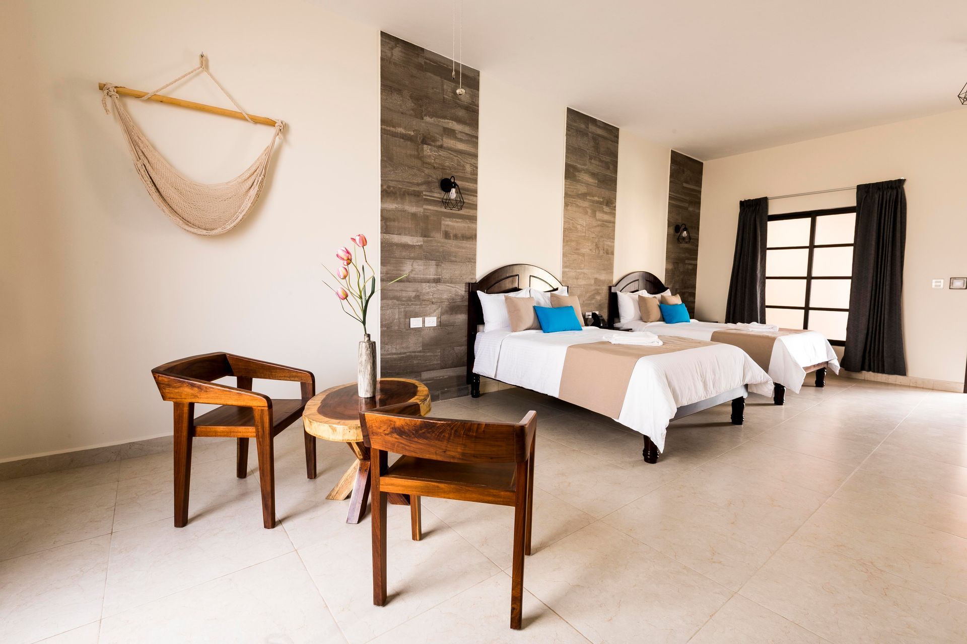 A hotel room with two beds , two chairs and a table.