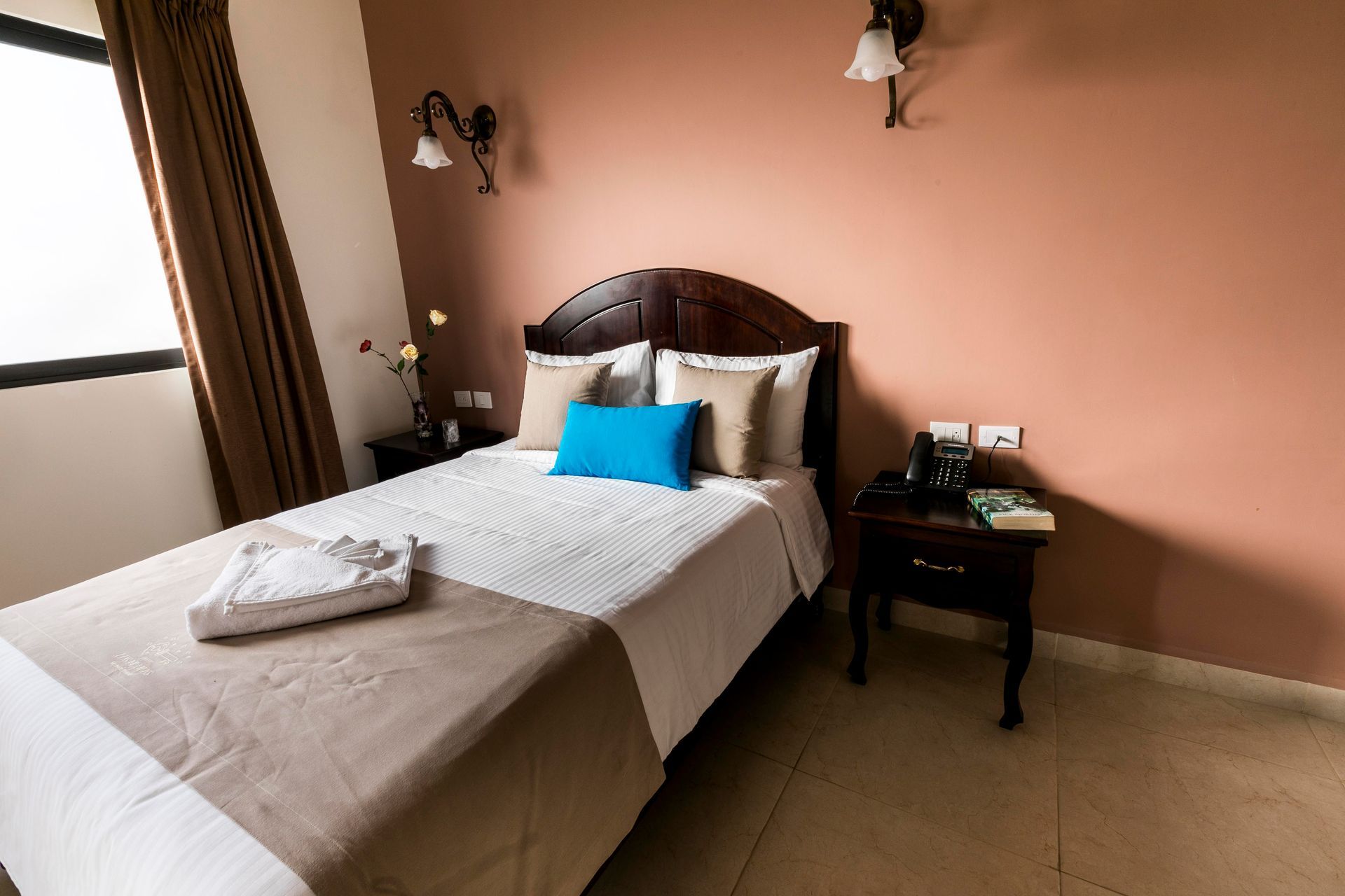 A hotel room with a bed and a nightstand