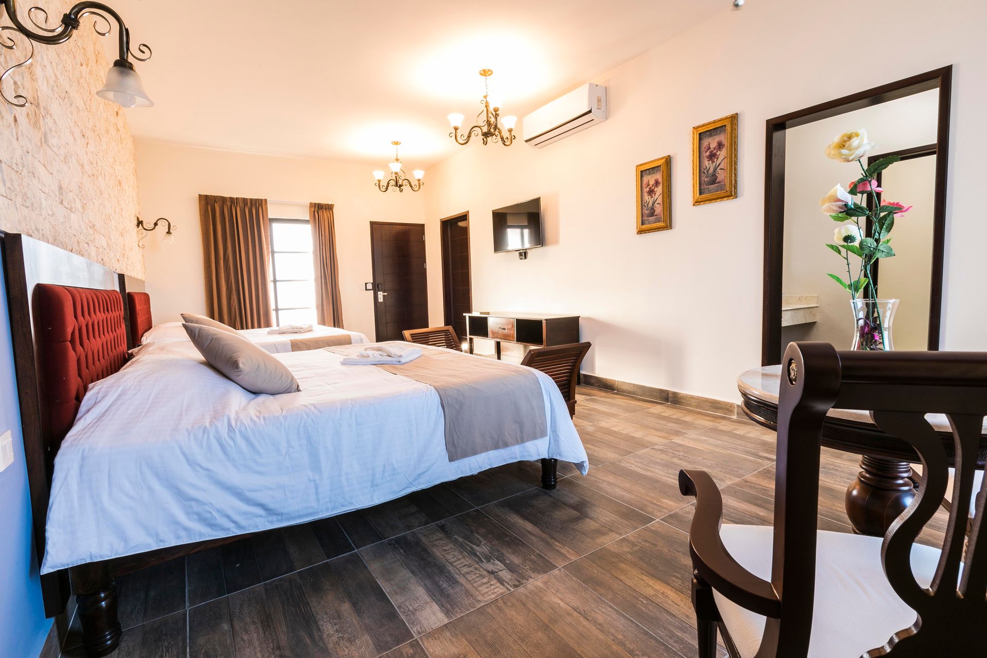 A hotel room with two beds , a table and chairs.