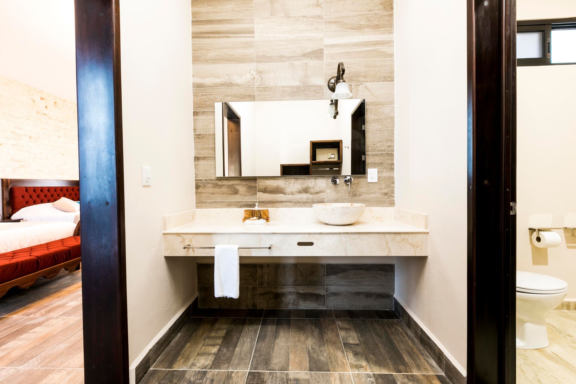 A bathroom with a sink , mirror and toilet.