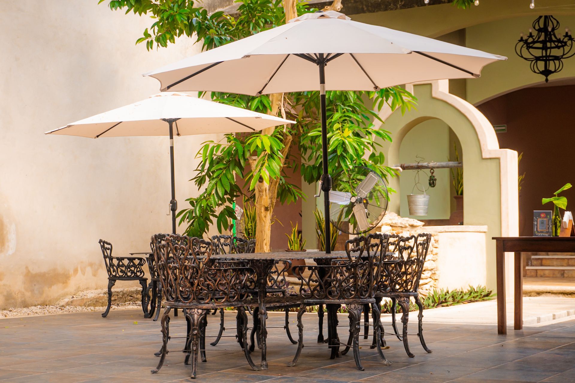 A table and chairs under umbrellas in a courtyard