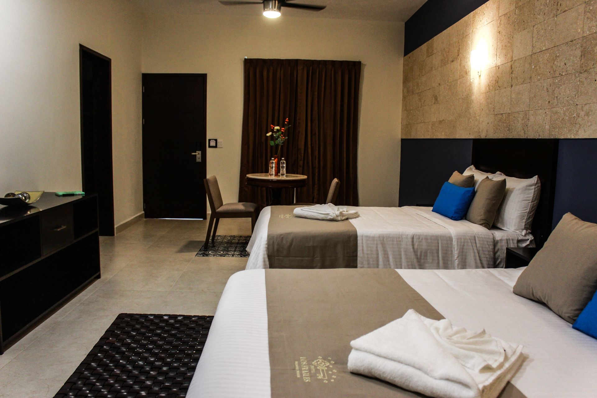 A hotel room with two beds and a table.