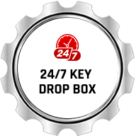 Silver gear badge with red 24/7 icon and the words “24/7 Key Drop Box