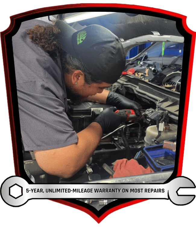 Auto technician performing vehicle inspection and diagnostic service in repair shop