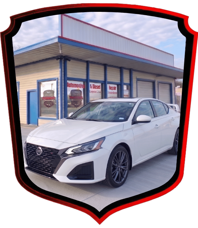 White Nissan sedan parked outside WrenchWerks automotive facility