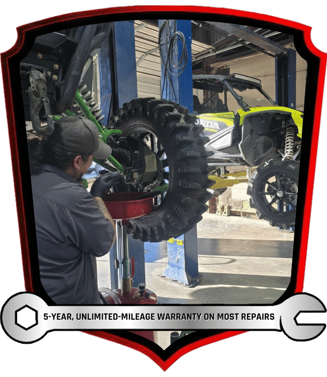 Technician servicing off-road side by side suspension and drivetrain components