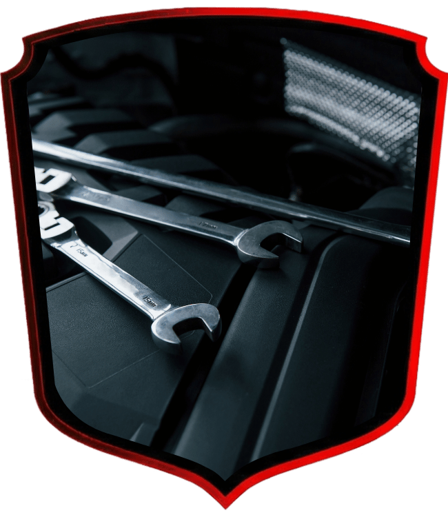 Mechanic wrenches resting across modern vehicle engine cover