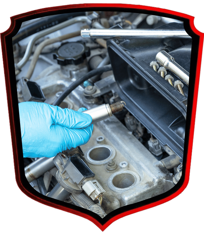 Technician replacing spark plug in vehicle engine