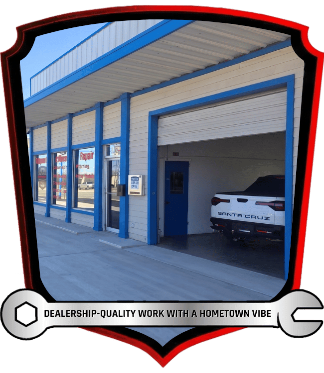 Auto repair shop exterior with open service bay and Hyundai Santa Cruz