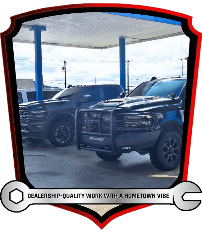 Lifted pickup trucks parked outside automotive repair shop