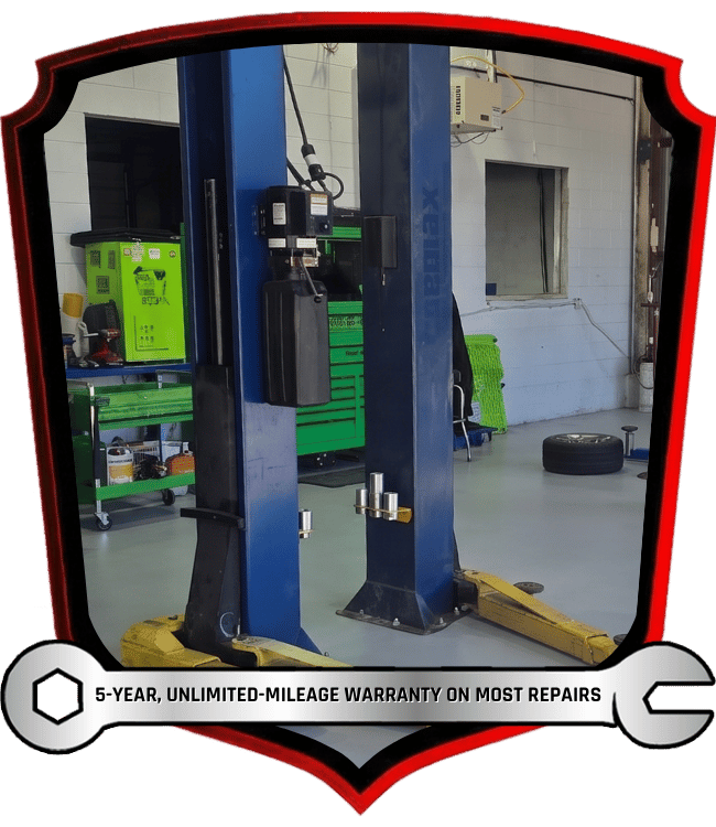 Vehicle lift inside automotive repair shop service bay with tool storage area