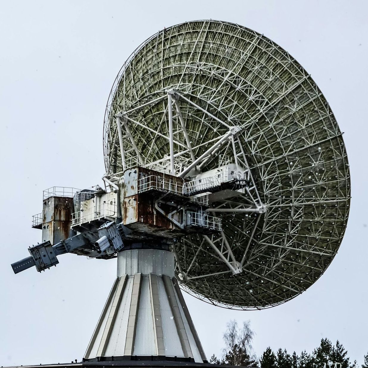 A large satellite dish is sitting on top of a pyramid.