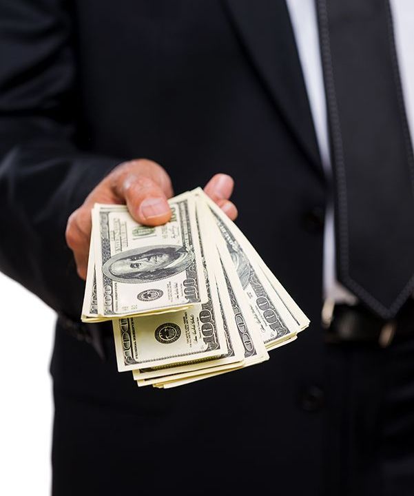 A man in a suit and tie is holding a stack of money