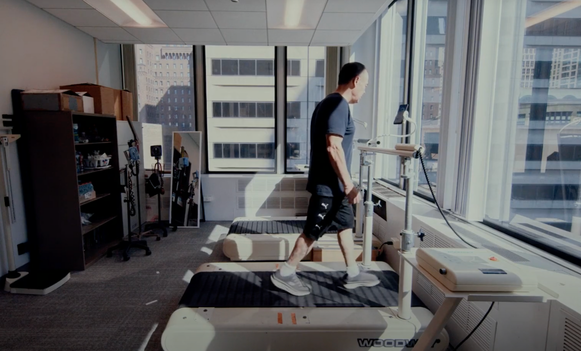 A man is walking on a treadmill in an office.