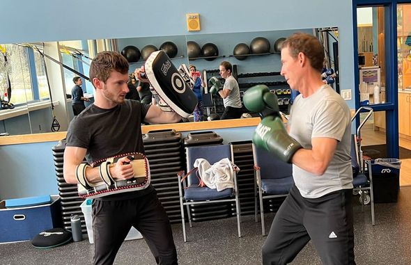 Two men are practicing martial arts in a gym.