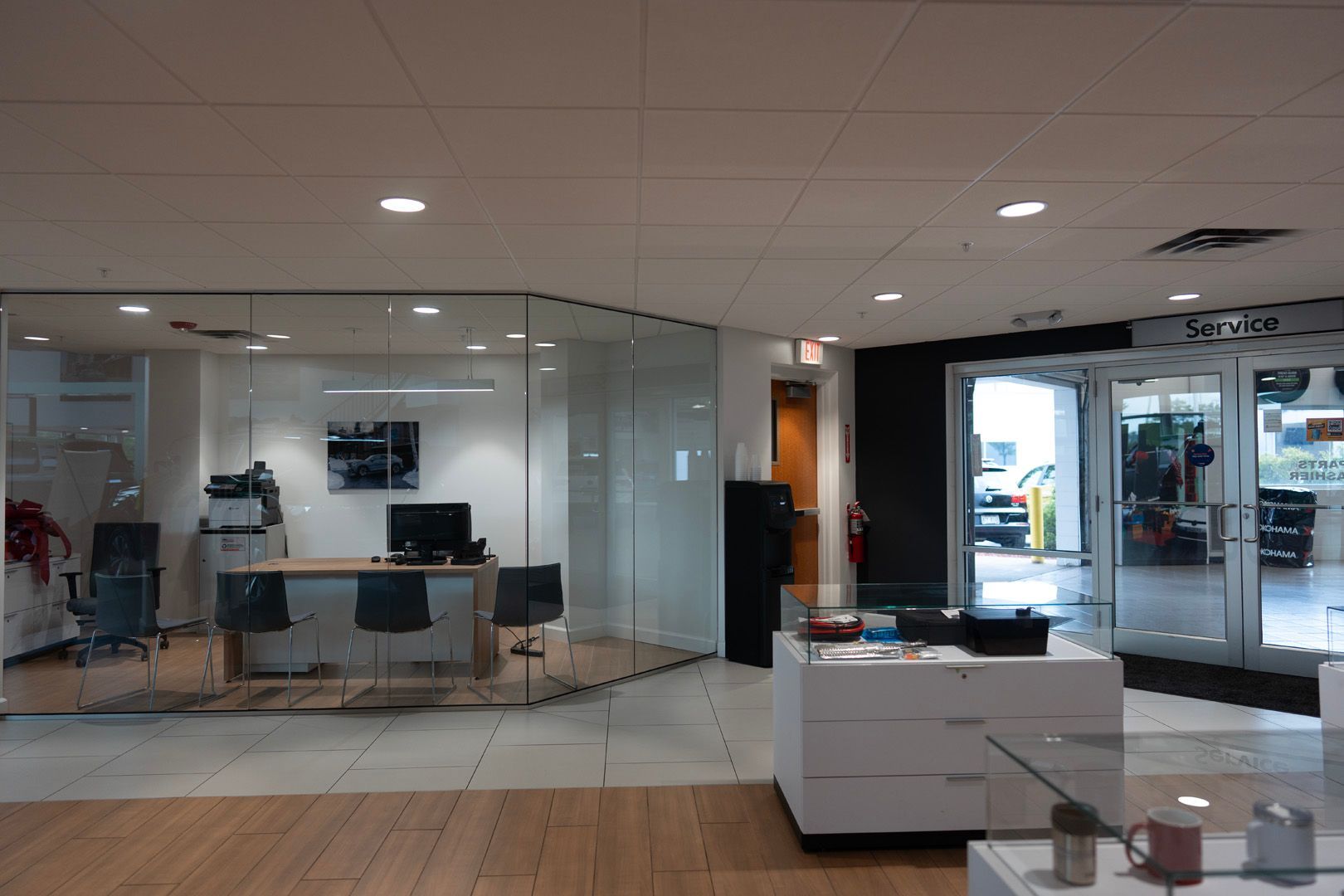 A car dealership with a desk and chairs in the middle of the room.