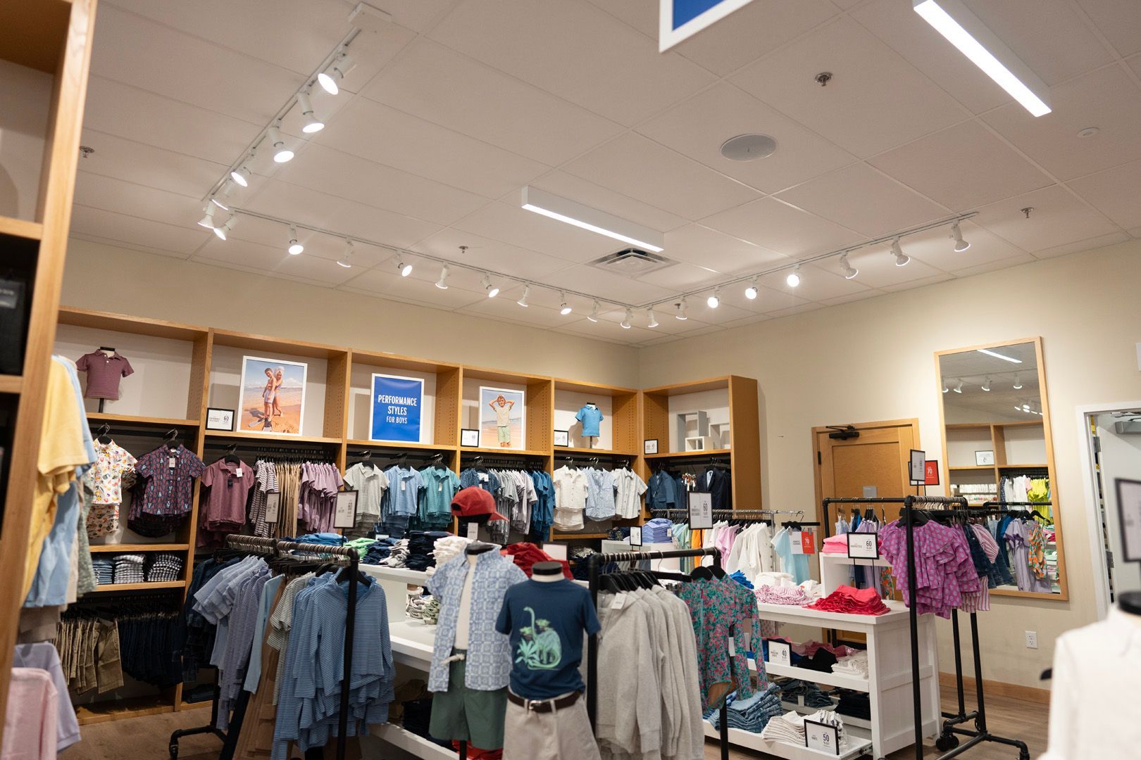 A store filled with lots of clothes and a mirror.
