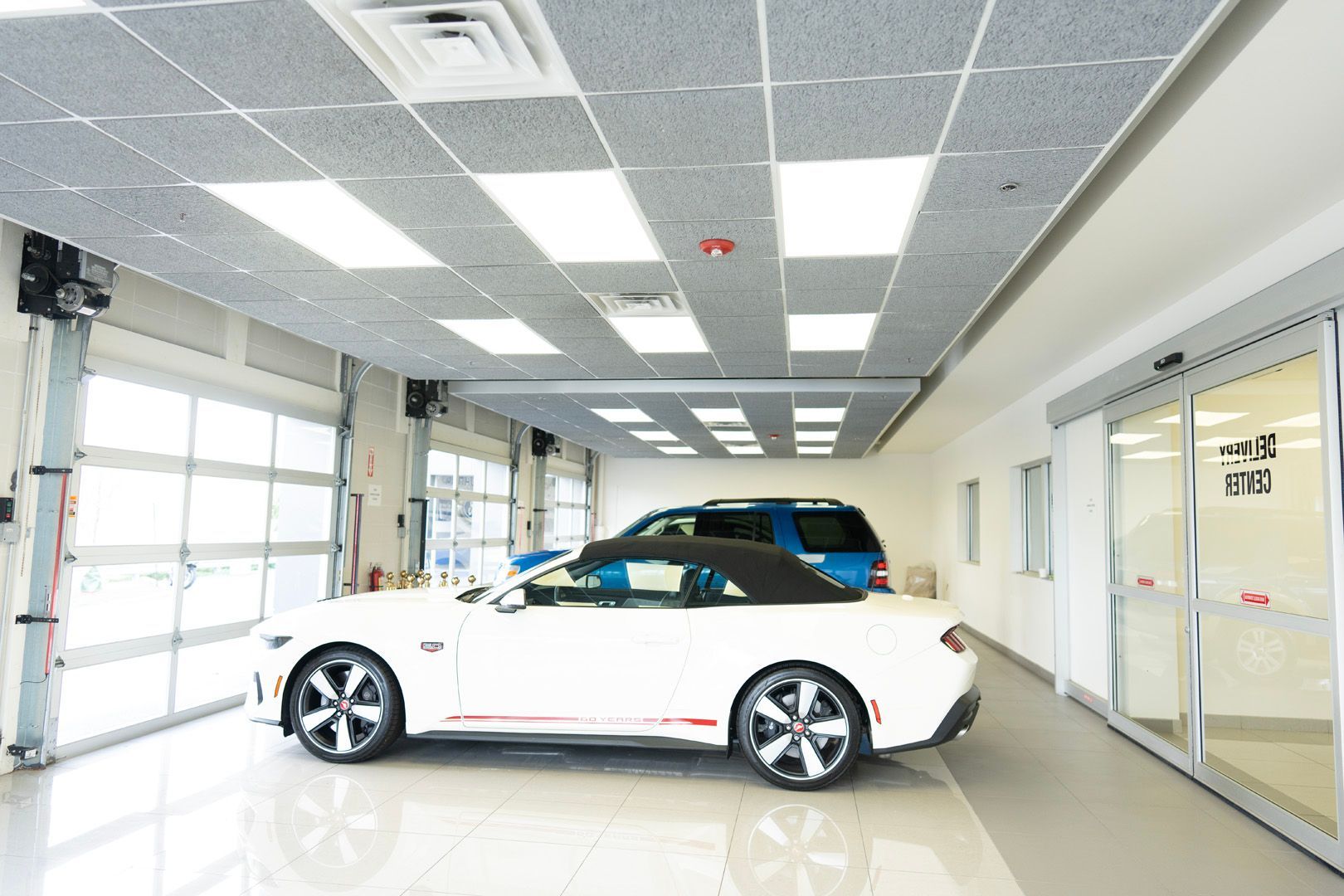 A white car is parked in a garage with a sliding glass door.
