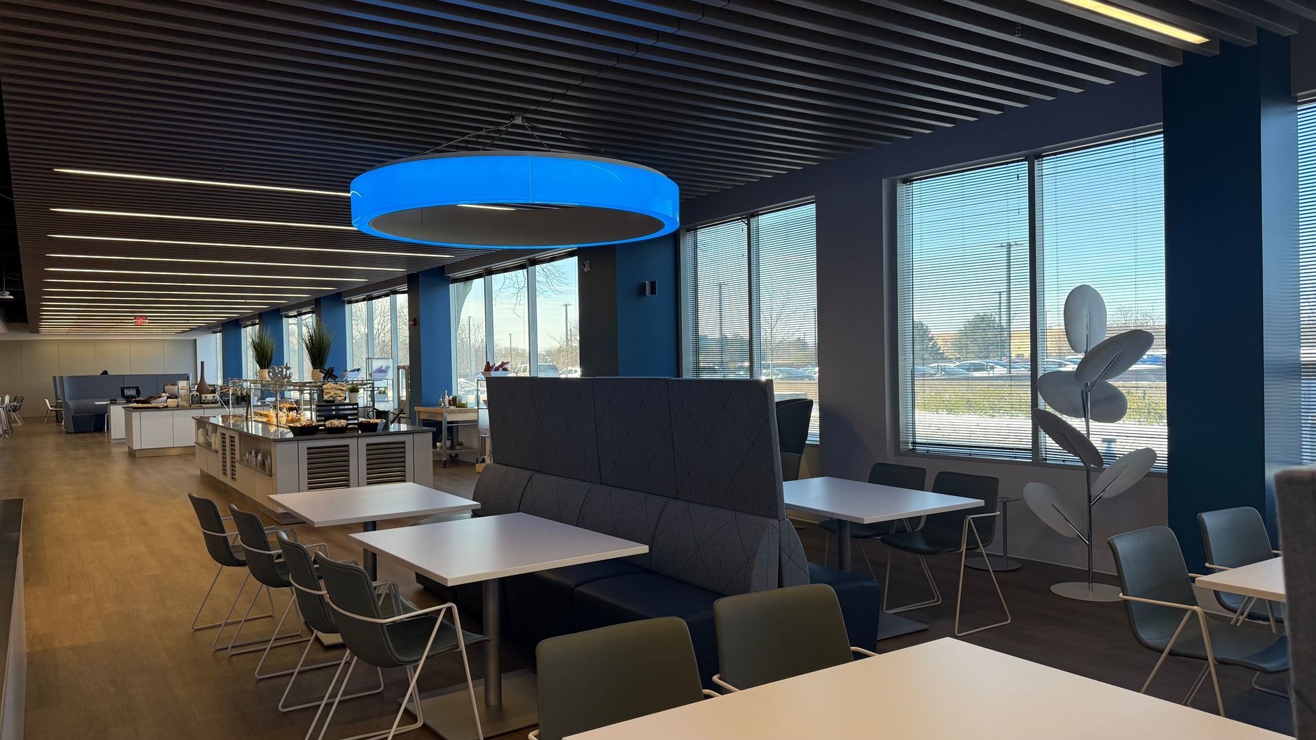 A restaurant with tables and chairs and a blue light hanging from the ceiling.